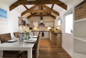 a kitchen and dining room with a white table and chairs at Lavender Cottage - Gonwin Manor in Carbis Bay