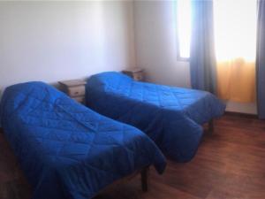 Habitación con 2 camas azules y ventana. en MADRESELVA en San Rafael
