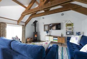 a living room with blue couches and a fireplace at Sunflower Cottage - Gonwin Manor in Carbis Bay