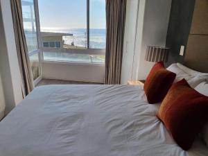 a bedroom with a bed with a view of the ocean at Lovely Apartment in Milnerton in Cape Town