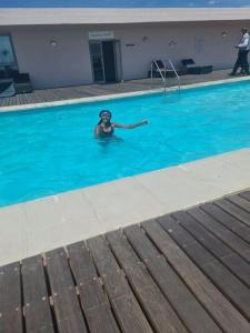 a woman swimming in a swimming pool at Lovely Apartment in Milnerton in Cape Town