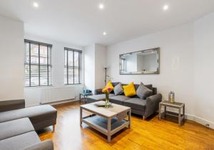 a living room with a couch and a table at Two Bed Flat in Bush Hill Park in Enfield