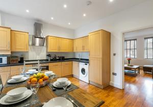 a kitchen with a table with a bowl of fruit on it at Two Bed Flat in Bush Hill Park in Enfield