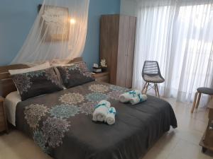 two stuffed animals sitting on a bed in a bedroom at House Near The Beach (Militsa & Aggeliki) in Perivolia