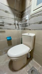 a bathroom with a white toilet in a room at Aladdin pyramids City 2 in Cairo