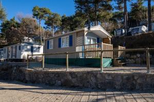 a house with a fence in front of it at Bungalows del Camping Pedraforca in Saldés