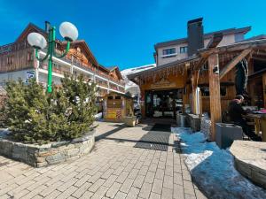 a street in a mountain town with trees and buildings at Atmosphere Hotel in Les Deux Alpes