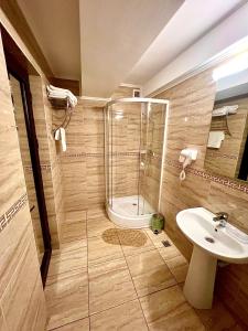 La salle de bains est pourvue d'une douche et d'un lavabo. dans l'établissement Complex Azar, à Galaţi