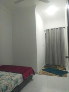 um quarto branco com uma cama e um chuveiro em Homestay ainnor em Pasir Puteh