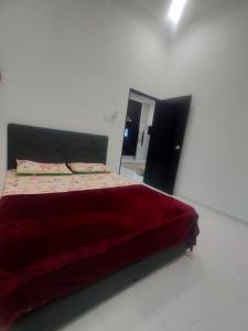 een slaapkamer met een groot rood bed en een spiegel bij Homestay ainnor in Pasir Puteh