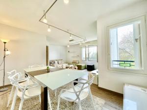 洛里昂的住宿－L'Orangerie - T4 - Centre ville - Wifi Fibre - Au calme - Lumineux，一间设有白色桌子和白色椅子的用餐室