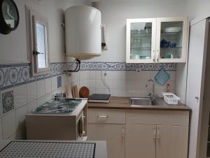 uma pequena cozinha com um lavatório e um fogão em Alfama with a view em Lisboa