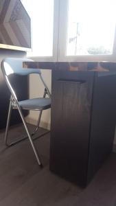 una sedia seduta accanto a una scrivania con finestra di Studio 2 lits jumeaux 1 station Tram aéroport Orly ad Athis-Mons