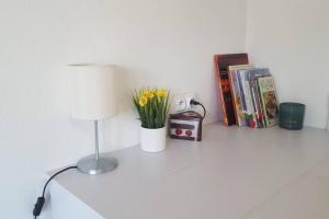 una mesa con una lámpara y libros en ella en Studio 2 lits jumeaux 1 station Tram aéroport Orly en Athis-Mons