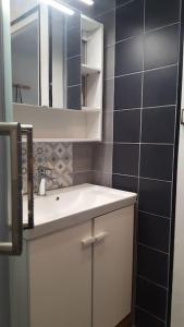 een badkamer met een witte wastafel en een spiegel bij Studio 2 lits jumeaux 1 station Tram aéroport Orly in Athis-Mons