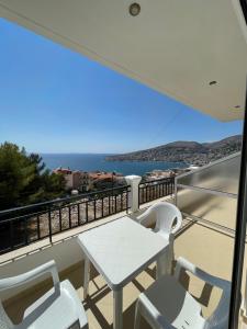 un tavolo e sedie su un balcone con vista sull'oceano di Villa Sildi a Sarandë