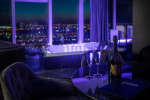 a table with a bottle of wine and two wine glasses at In The Sky - Apartamenty w Sky Tower in Wrocław