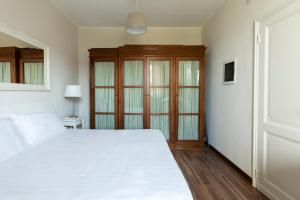 sypialnia z białym łóżkiem i drewnianą szafką w obiekcie Montenapoleone - Sant Andrea Charme PentHouse w Mediolanie