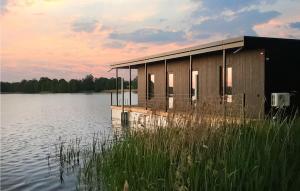 a small building on a dock on a lake at Pet Friendly Ship In Kruklanki With Lake View in Kruklanki