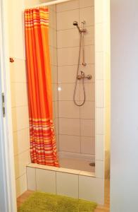 La salle de bains est pourvue d'une douche avec un rideau de douche orange. dans l'établissement Dom prywatny, à Przesieka