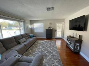 a living room with a couch and a television at The perfect Gulfport Fl Getaway! in St. Petersburg