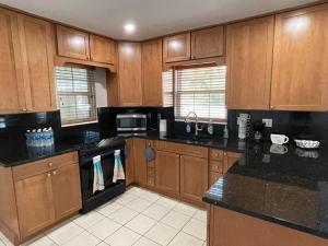 a kitchen with wooden cabinets and black counter tops at The perfect Gulfport Fl Getaway! in St. Petersburg