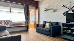 a living room with a couch and a television at Sun & Sea 509 in Sesimbra