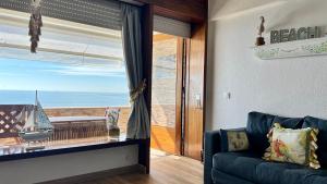 a living room with a couch and a view of the ocean at Sun & Sea 509 in Sesimbra