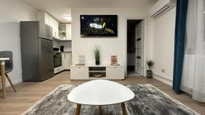 a living room with a white table and a kitchen at Bogdan's Ultracentral Residence 1 in Timişoara