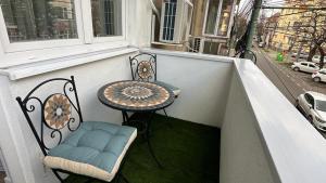 a small table and chairs on a balcony with a table at Bogdan's Ultracentral Residence 1 in Timişoara