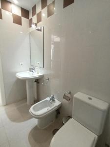 a white bathroom with a toilet and a sink at Casa Palacio Arcos del Carmen in Jerez de la Frontera +19 photos