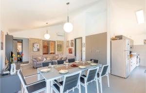 a kitchen and living room with a table and chairs at Nice Home In Kneze With Wifi in Pupnat