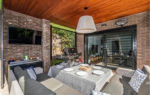 eine Terrasse mit einem Tisch und Stühlen sowie einem TV in der Unterkunft 4 Bedroom Awesome Home In Cabrils in Cabrils