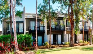 un immeuble d'appartements avec des arbres devant lui dans l'établissement Margarets Forest, à Margaret River Town