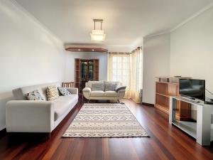 un soggiorno con un divano bianco e una TV di Milagres Apartment by Atlantic Holiday a Machico