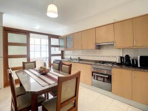 una cucina con un tavolo e una sala da pranzo di Milagres Apartment by Atlantic Holiday a Machico