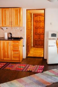a kitchen with a wooden door and a refrigerator at Gazdov dvor in Vavrišovo
