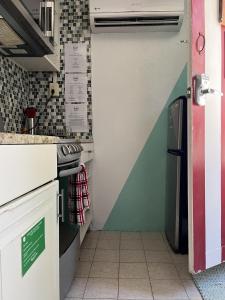 a small kitchen with a sink and a refrigerator at Coqui del Mar - LGBTQ Hotel - Adults Only in San Juan