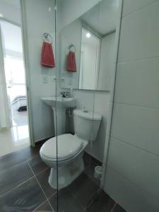 Baño blanco con aseo y lavamanos en Nueva Suite De Lujo Familiar excelente ubicación, en Villavicencio