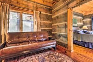 un sofá de cuero en una habitación con cama en The Cabin at Marys Place with Deck and Mtn Views! en Maggie Valley