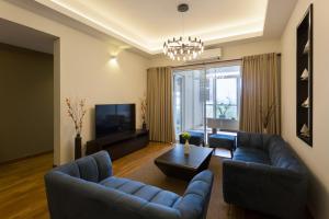 a living room with two blue couches and a television at Niwahas Apartment Borella in Colombo