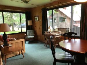 een woonkamer met een tafel, stoelen en ramen bij Covewood Lodge 