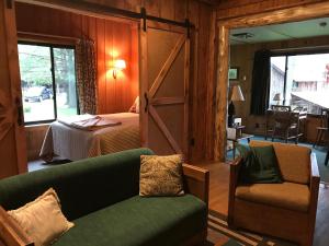 een woonkamer met een bed en een bank en een slaapkamer bij Covewood Lodge 