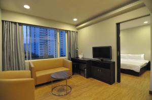 Habitación de hotel con cama, sofá y TV en Keys Select by Lemon Tree Hotels, Kochi, en Kochi