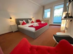 a bedroom with a large bed with red pillows at Hotel Rathaus in Wildemann