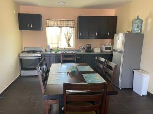 a kitchen with a table and chairs and a refrigerator at Condominio puerto peñasco in Puerto Peñasco