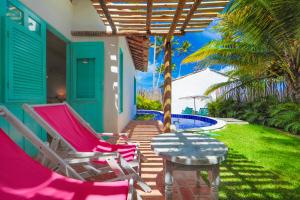 佩德拉斯港的住宿－Pousada Patacho，一个带两把椅子和一张桌子的庭院和一个游泳池