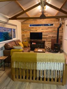 a living room with a couch and a television at The Shack plus Camping in Llandinam
