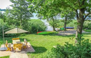 a backyard with a table and chairs and an umbrella at Awesome Home In Srokowo With 6 Bedrooms, Wifi And Sauna in Srokowo
