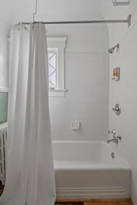 a white bath tub with a shower curtain in a bathroom at The Hartness House in Springfield